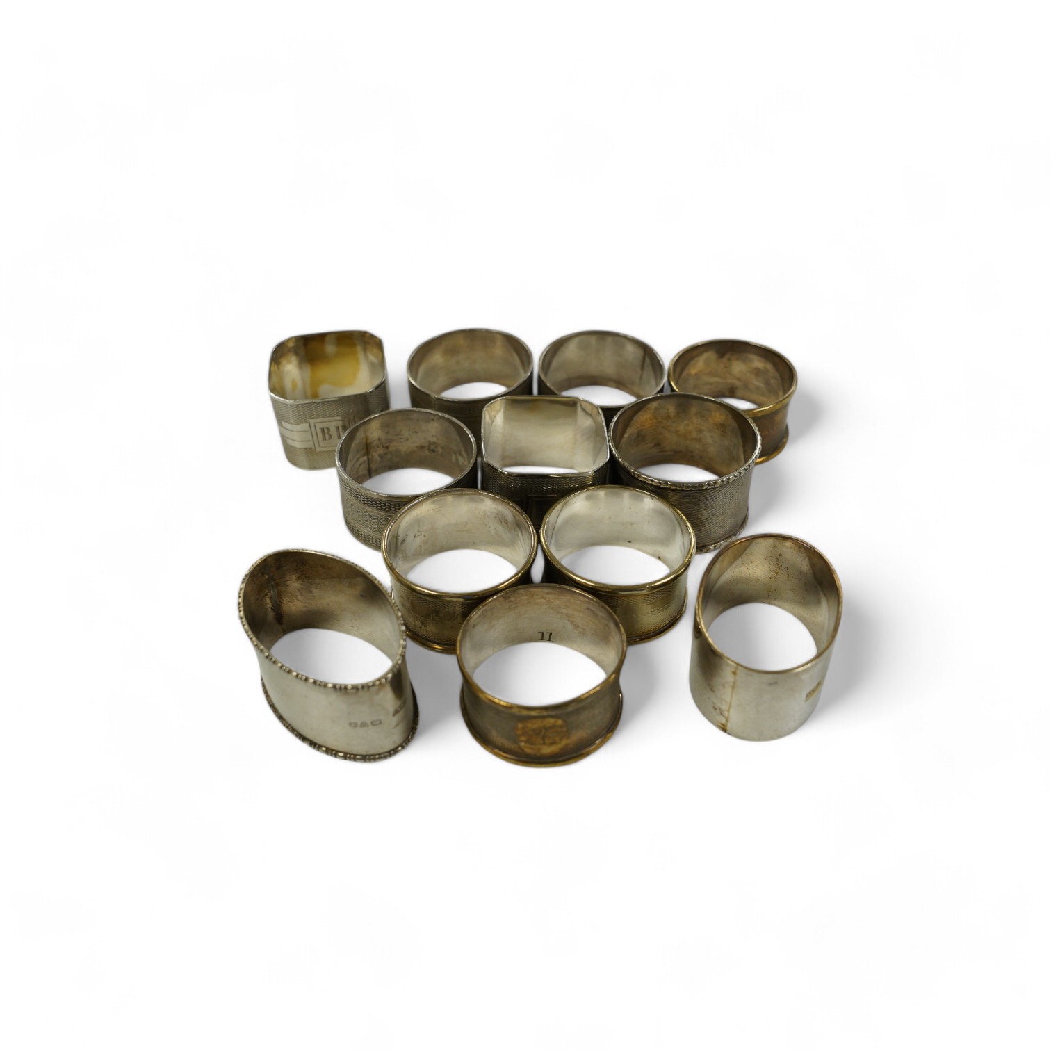 Eight assorted silver napkin rings, including a pair, Birmingham, 1937 and four plated napkin rings. Condition - fair